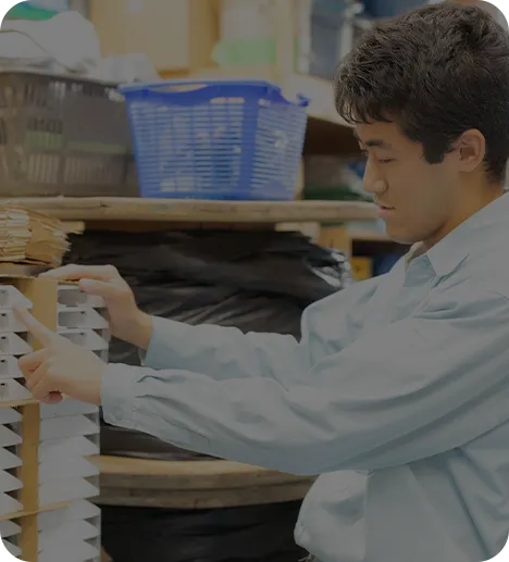 資材の在庫を確認する作業服の男性スタッフ