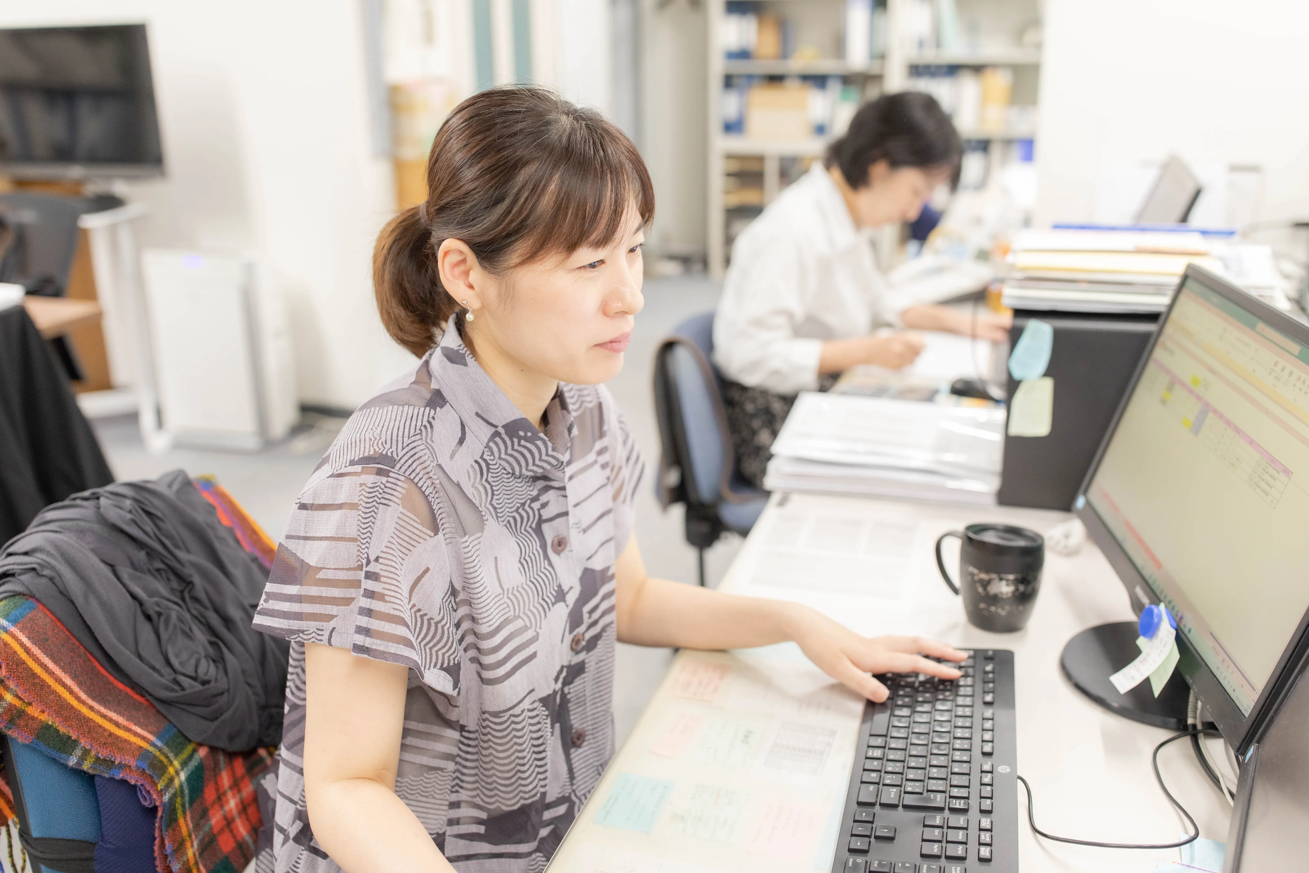 パソコンで書類作成を行う総務部の女性スタッフ