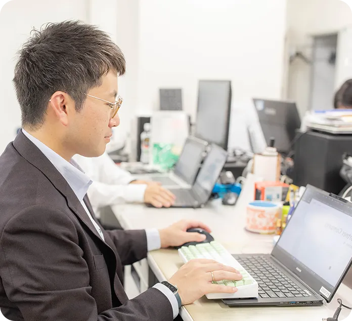 パソコンで書類作成を行う総務部の男性スタッフ