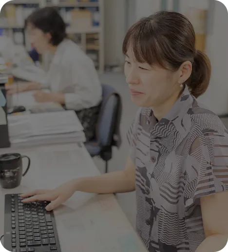 パソコンで書類作成を行う総務部の女性スタッフ