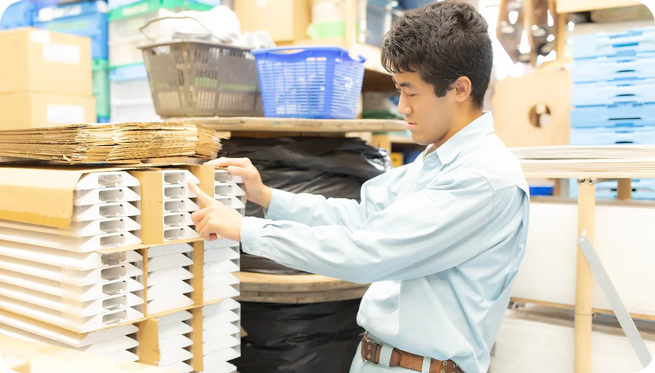 資材の在庫を確認する作業服の男性スタッフ