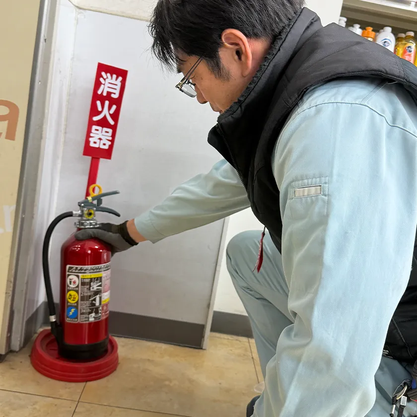 消火器の設置作業を行うスタッフ