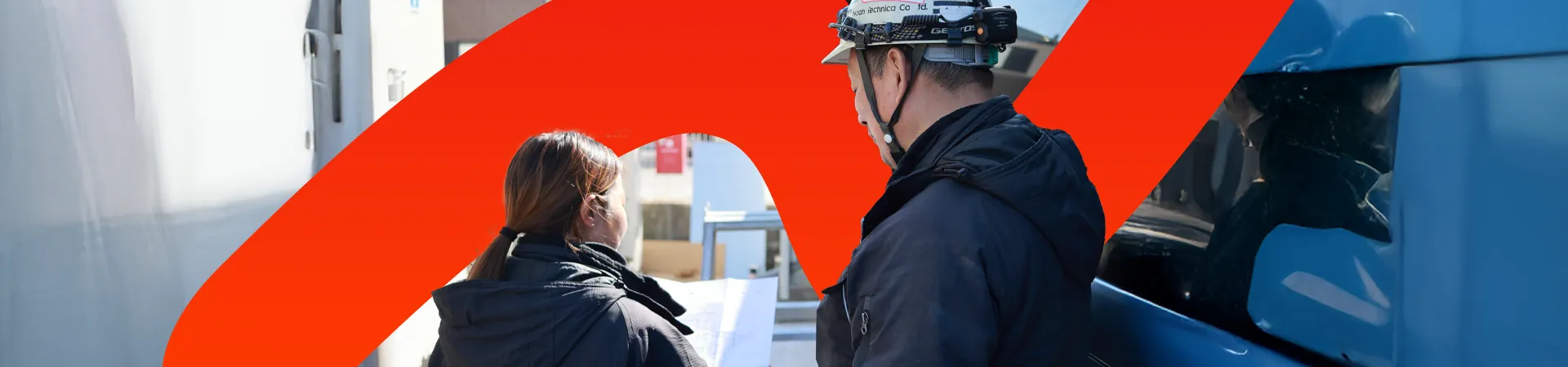 設計図を見ながら相談する男女スタッフ