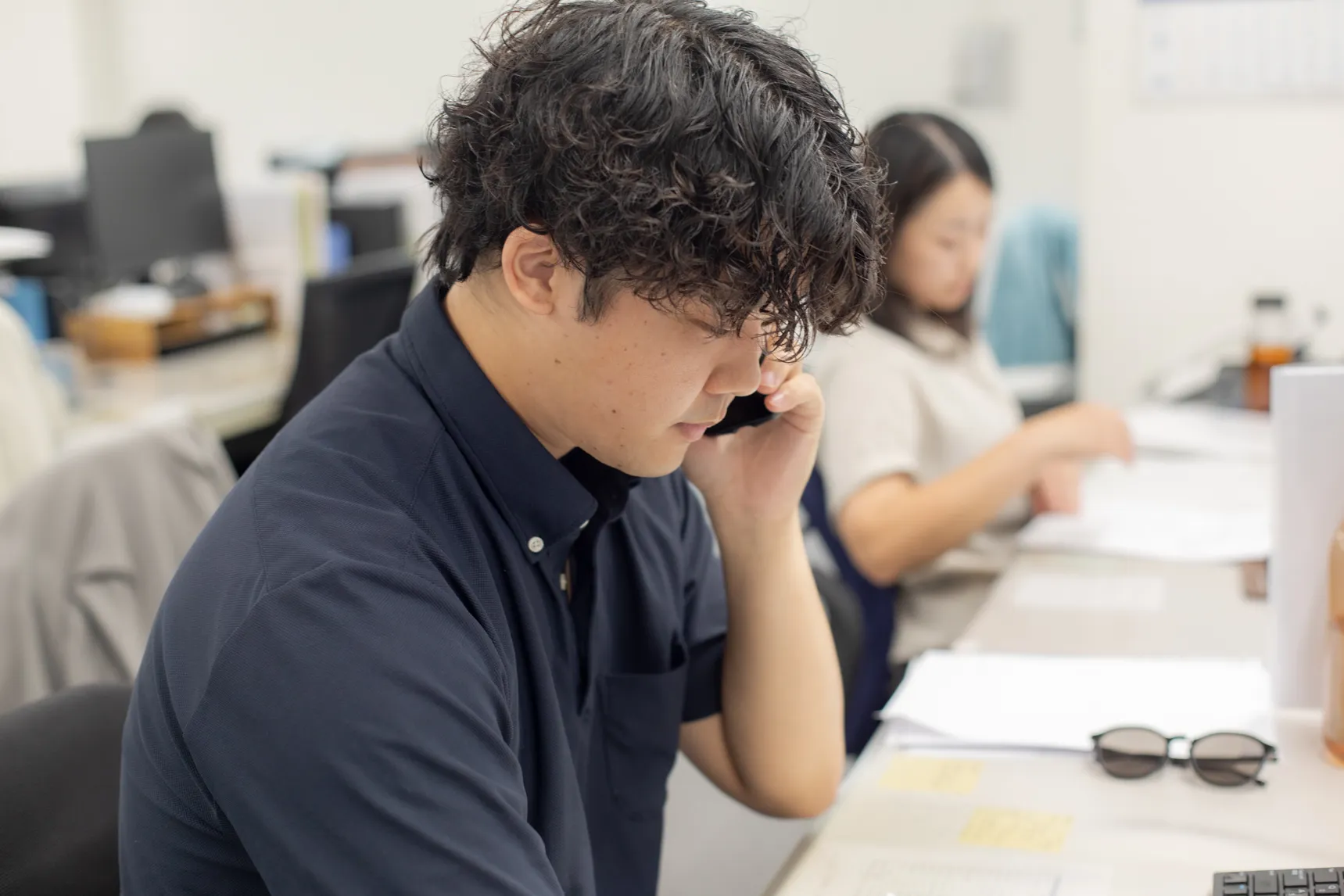 クライアントに電話する営業の男性スタッフ